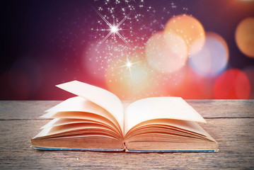 an open book with magical dust suspended above it